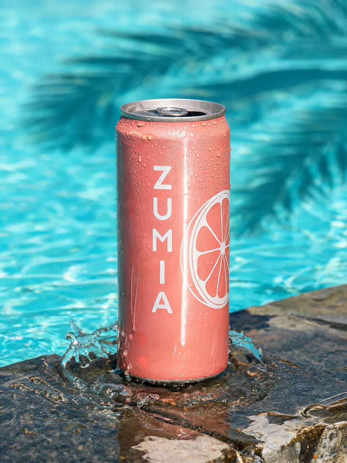 Slim coral ZUMIA can with a splash around its base on a wet pool edge, made with Seedream 5