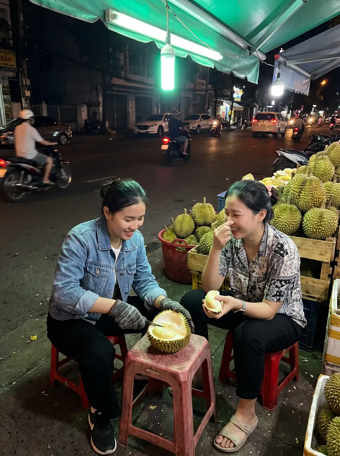 Two friends sharing a durian at a roadside stall at night, made with Nano Banana Pro